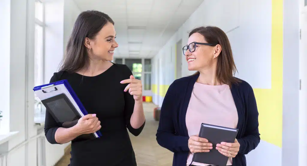 Two Teachers speaking in a school corridor
