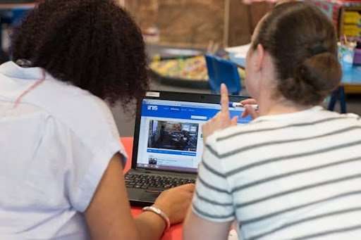 Two teachers viewing an IRIS Connect reflection on a laptop